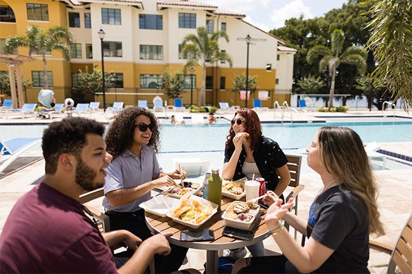 Rollins students gather outside Fox Lodge to connect and relax over a delicious meal.